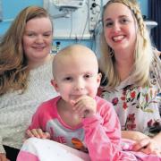 Lydia McConnell with her mother Charis, left, and godmother, Lorna Taylor, in the isolation ward at the Piam Brown unit