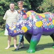 Mouth and foot artist Tom Yendell with wife Lucy and the rhino he has decorated for the project.