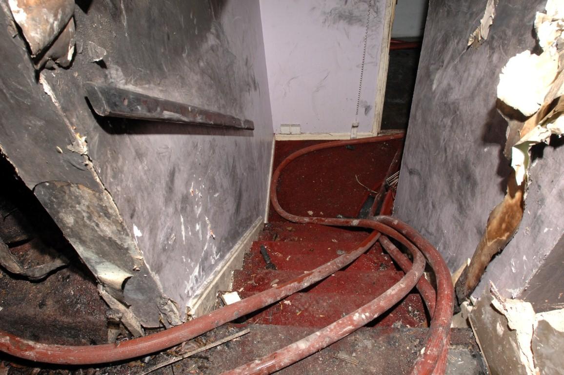 Looking down the stairs inside flat 72, with the distinctive red hoses laid by the firefighters as they fought the fire.