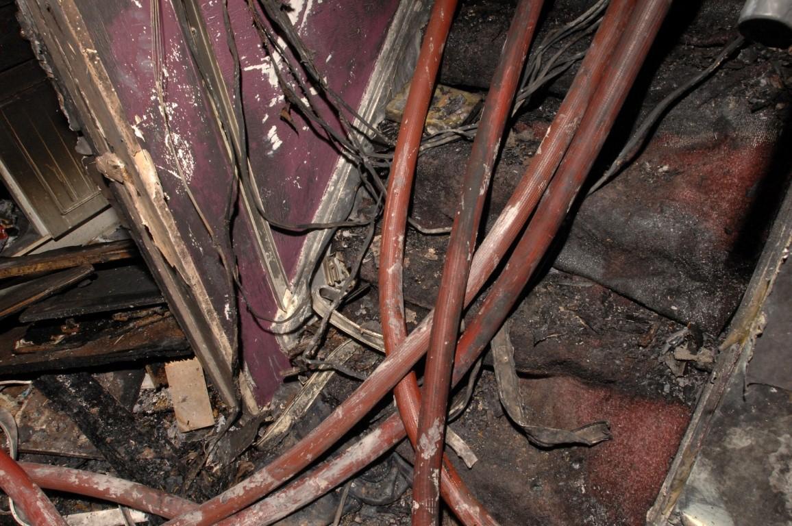 Hoses laid by the firefighters on the stairway inside the fire damaged flat alongside some of the cabling which had fallen, hampering the efforts of firefighters who became tangled.