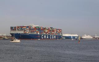 CMA CGM Antoine de Saint Exupery dwarfs the other vessels it passes in the Port of Southampton