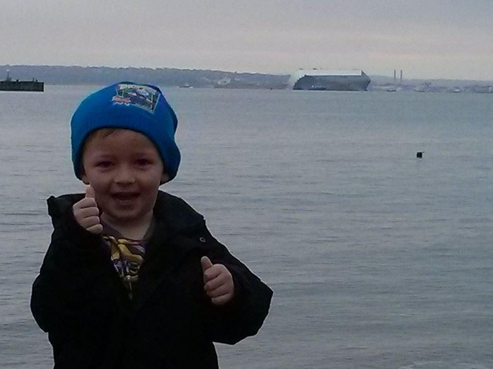 Isaac Burrow at Calshot beach with the ship in the background.