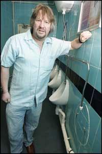 HOLE ON THE WALL: Landlord Alan Dreja at the site of the missing urinal.