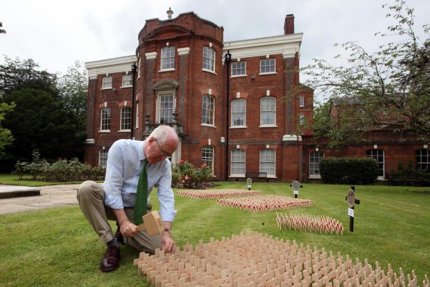 Lt Col Colin Bulleid with crosses for the 1280 men of the Hampshire Regiment who died in the Somme campaign, pictured in the memorial garden at Serle's House, Winchester